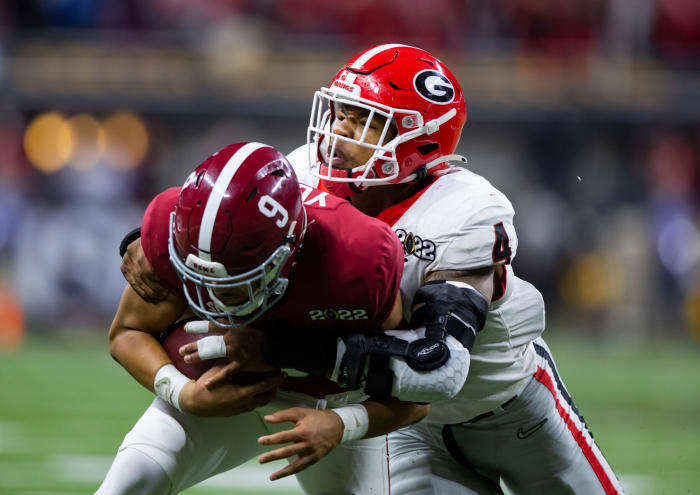 Nolan Smith brings down Alabama quarterback Bryce Young in the 2021-2022 national championship game.